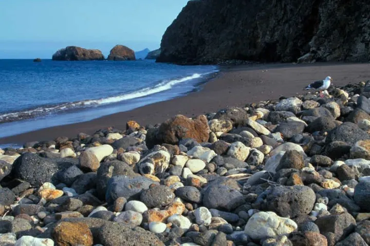 a rocky beach next to a body of water