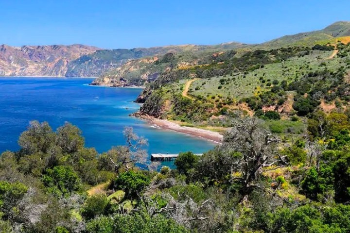 a large body of water with a mountain in the background