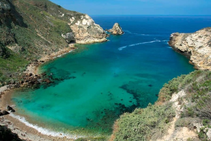 a rocky island in the middle of a body of water