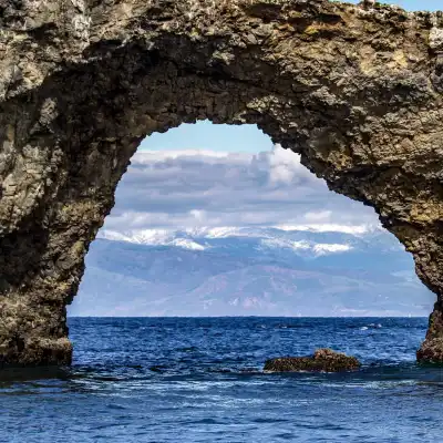 a man in a rocky area next to a body of water