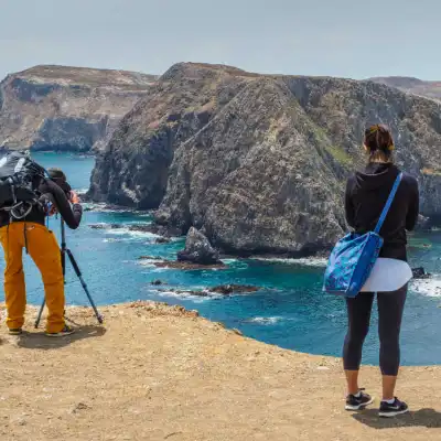 a man and a woman standing on a rocky beach