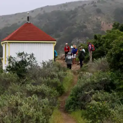 a group of people walking down a dirt road