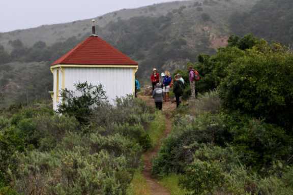 a group of people walking down a dirt road