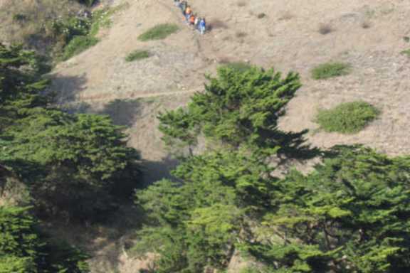 a group of people walking down a dirt road