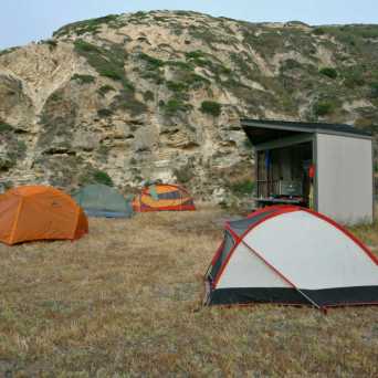 a tent in a field with a mountain in the background