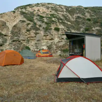 a tent in a field with a mountain in the background