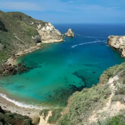 a rocky island in the middle of a body of water