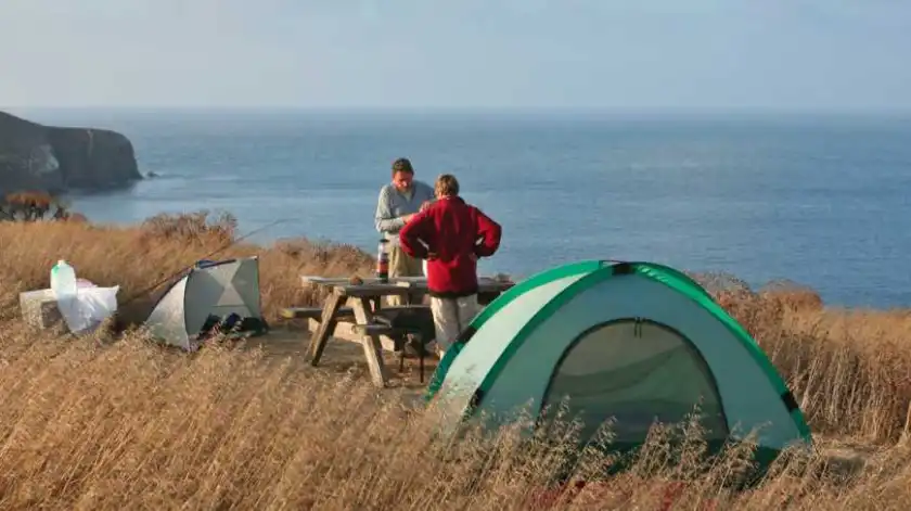 a man sitting in front of a body of water
