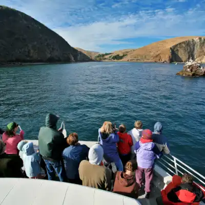 a group of people sitting in front of a body of water