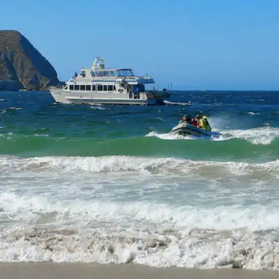 a man riding on the back of a boat in the ocean