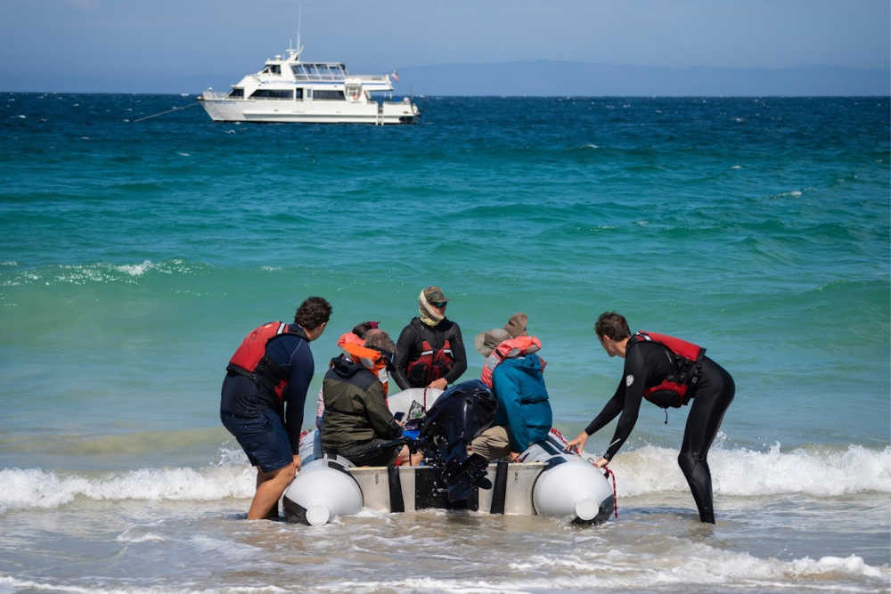 a group of people on a boat in the ocean