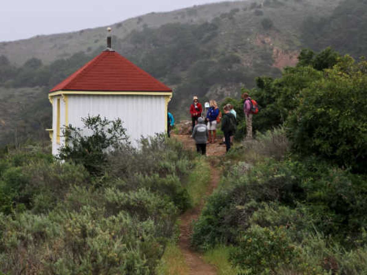 a group of people walking down a dirt road