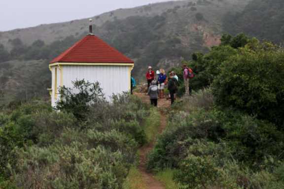 a group of people walking down a dirt road