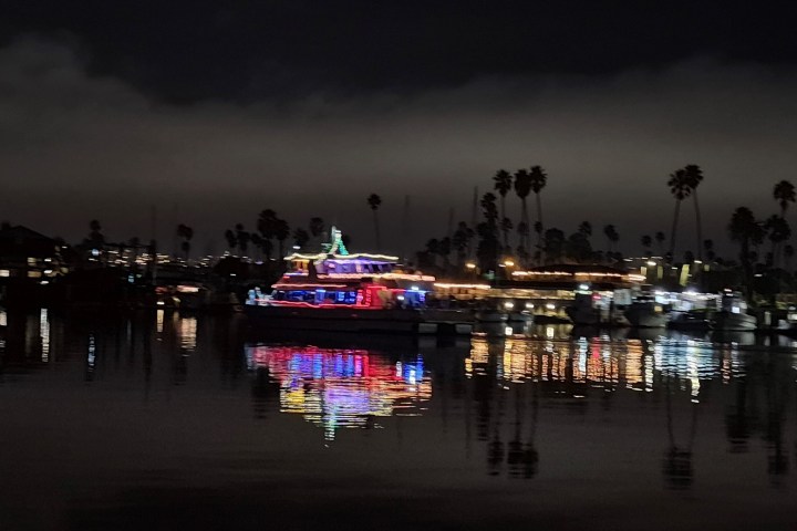 a small boat in a body of water with a city in the dark